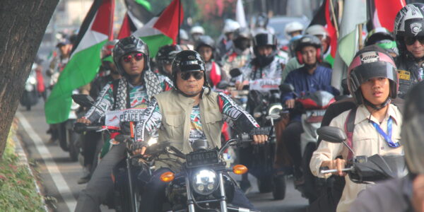 KH Bachtiar Nasir mengendarai sepedah motor besar, memimpin jalannya PEACE CONVOY, memperingati 1 Tahun Genozida di Gaza, bersama para peserta convoy yang juga berkendara motor, dengan atribut bendera Palestina